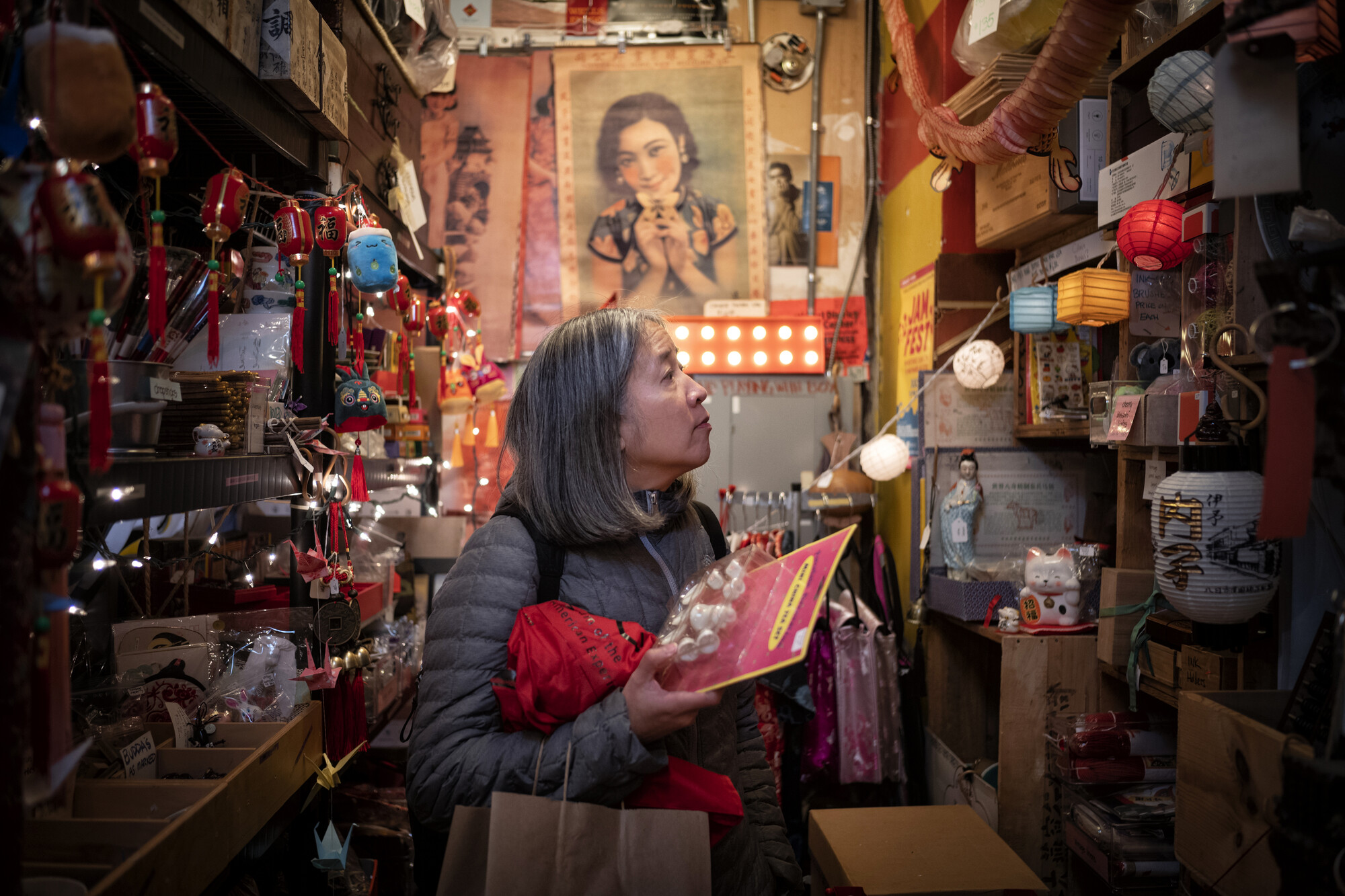 A woman in a crowded shop looking slightly upwards.