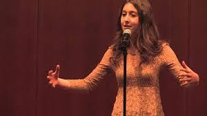A woman standing at a microphone.