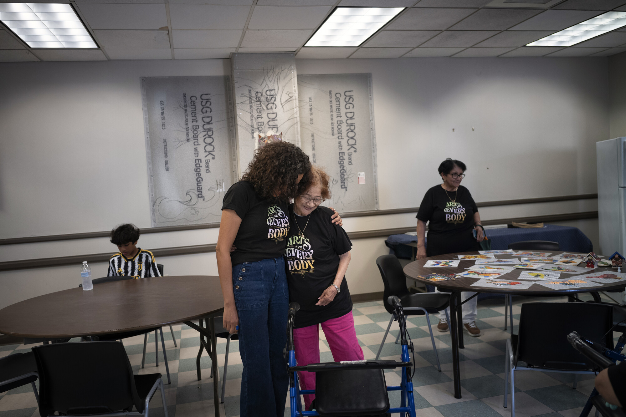 Two people in a multipurpose room hugging.