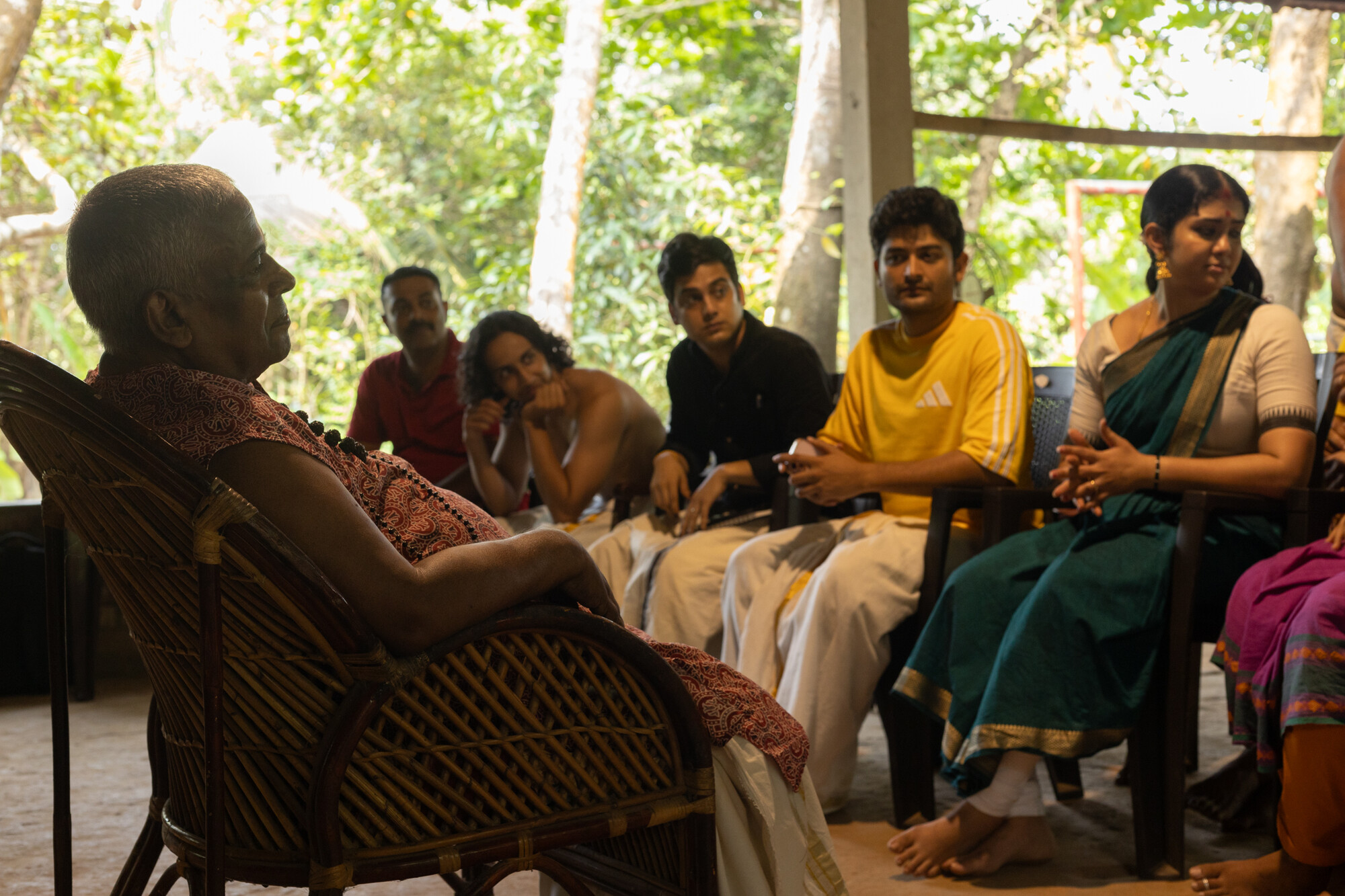A group of people sitting in chairs chatting.