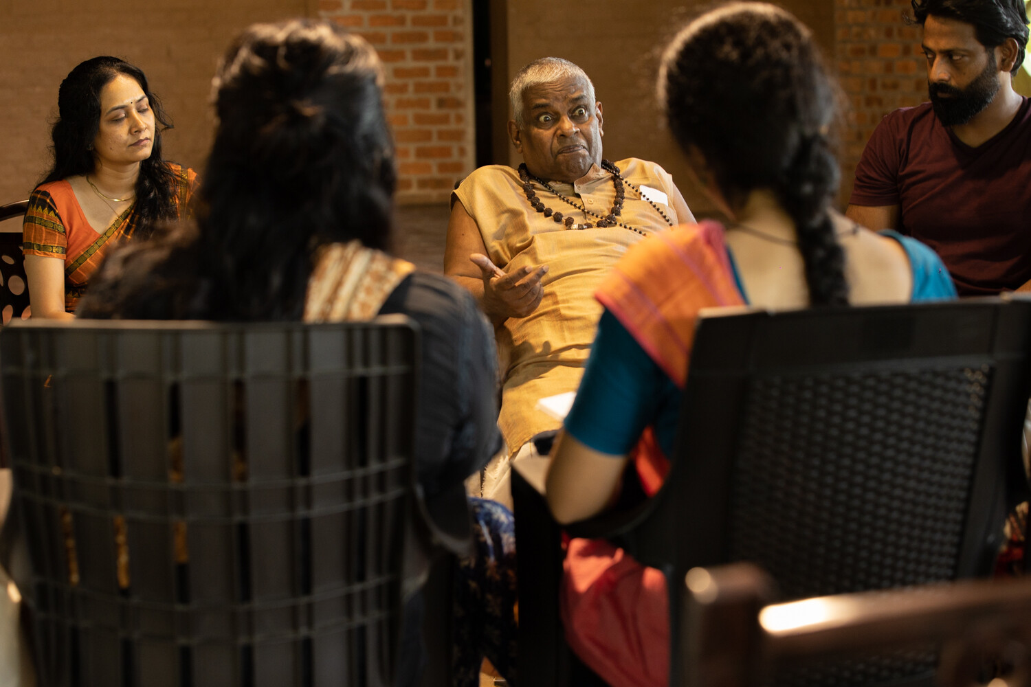 A close up of people sitting in chairs having a conversation.