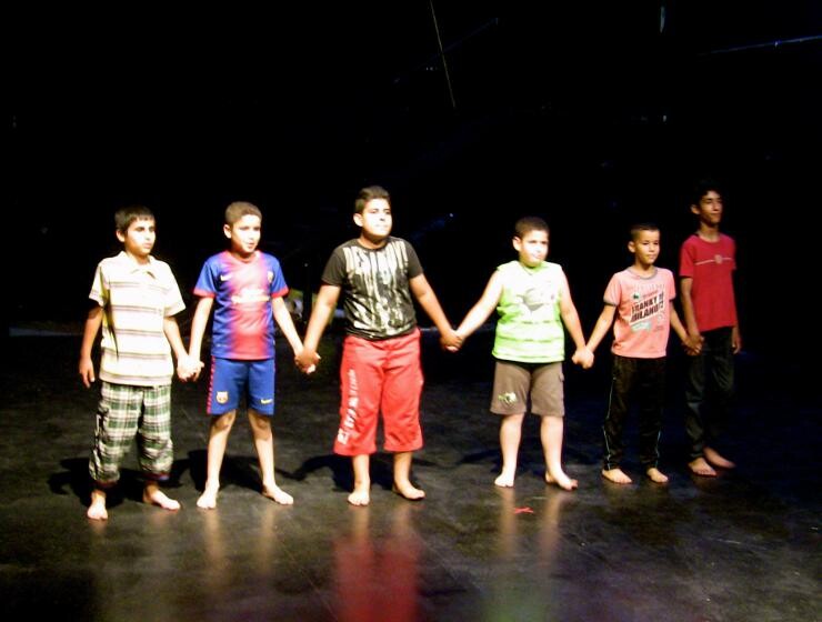 Children on stage holding hands.