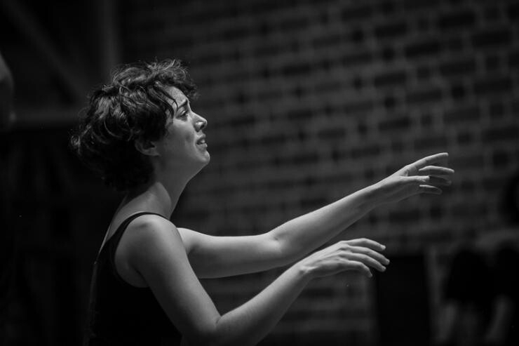 A black and white photo of a person crying and raising their hands in front of them.