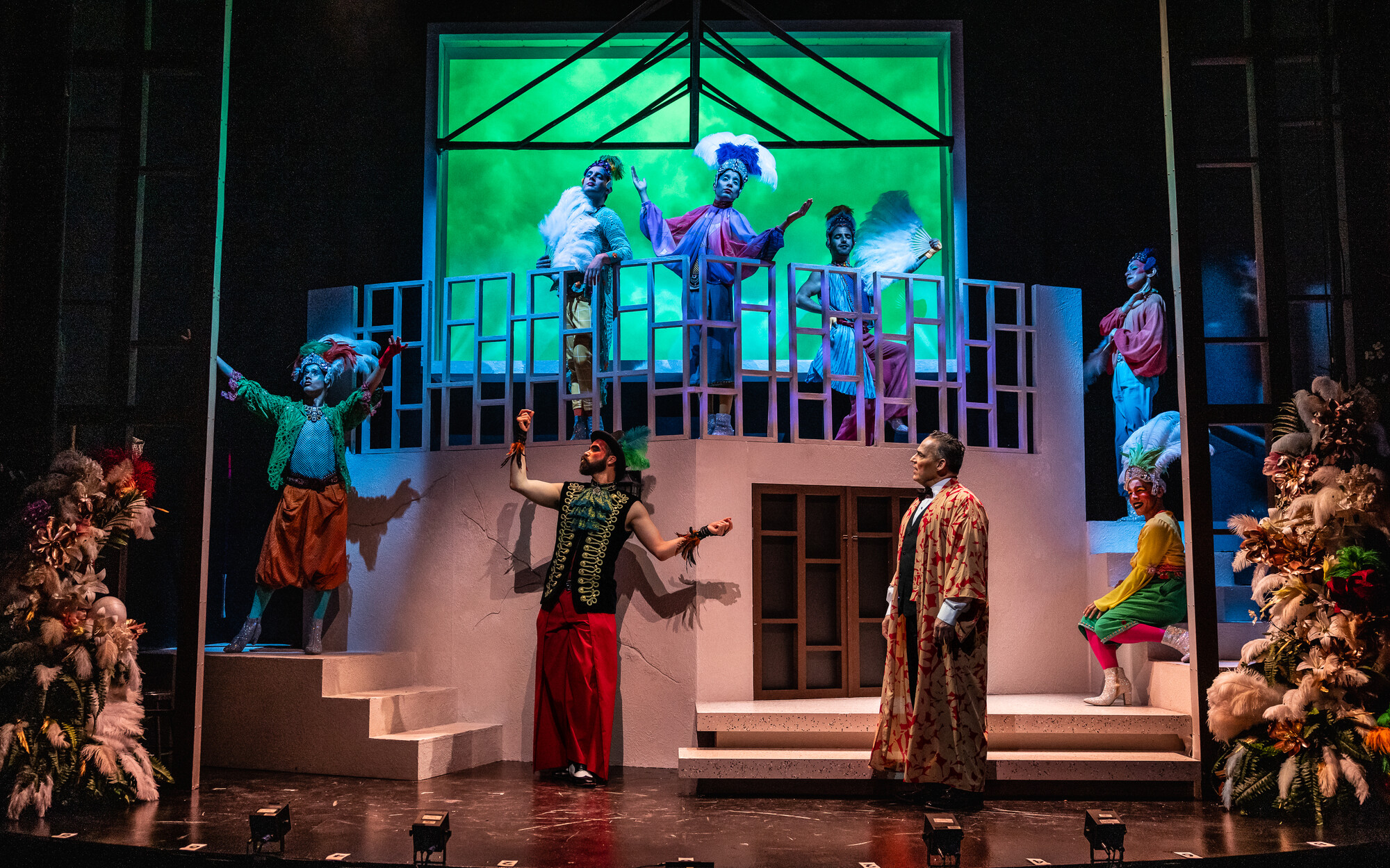 A set with a balcony and lots of actors.