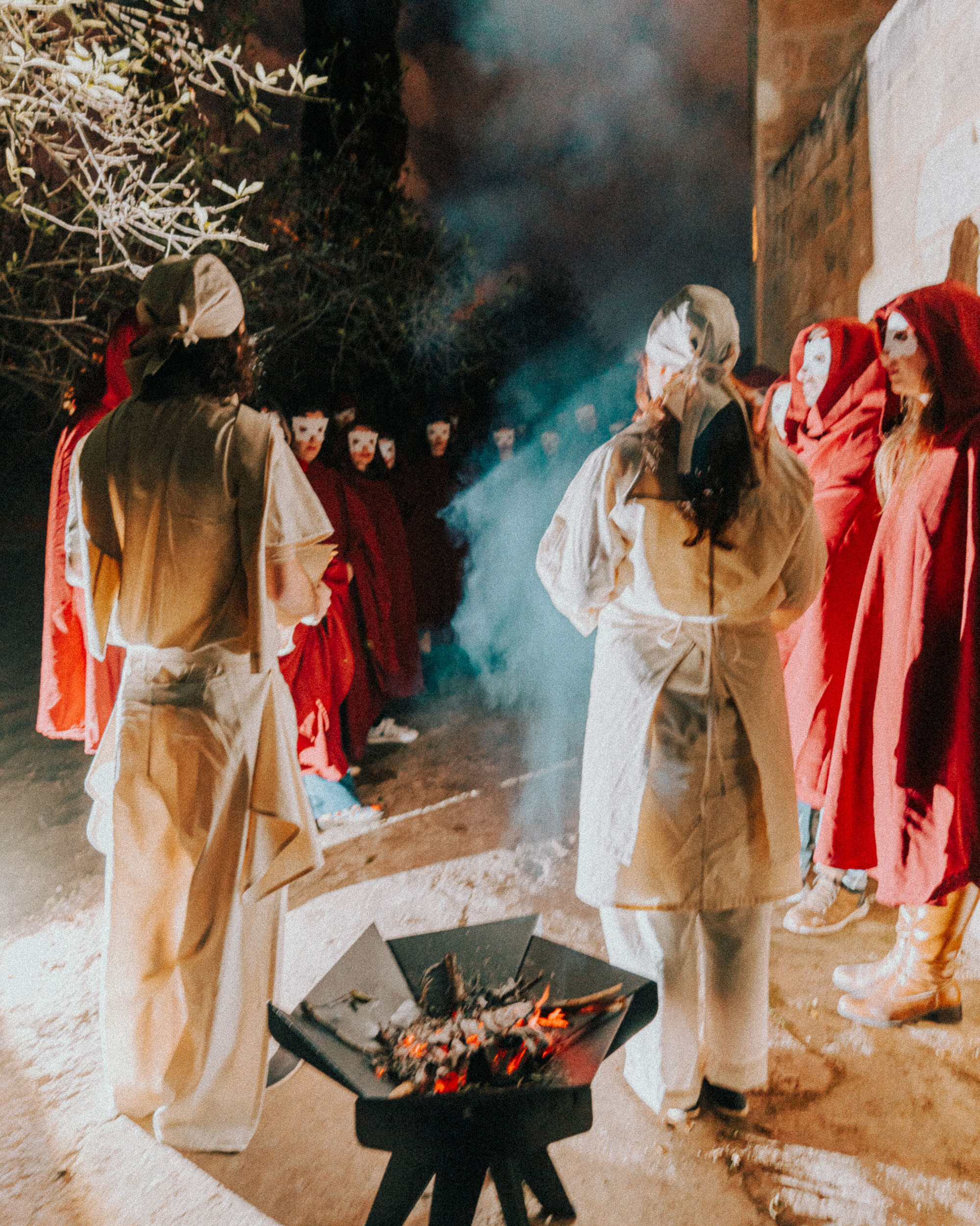 A group of actors in red and white robes standing outside.