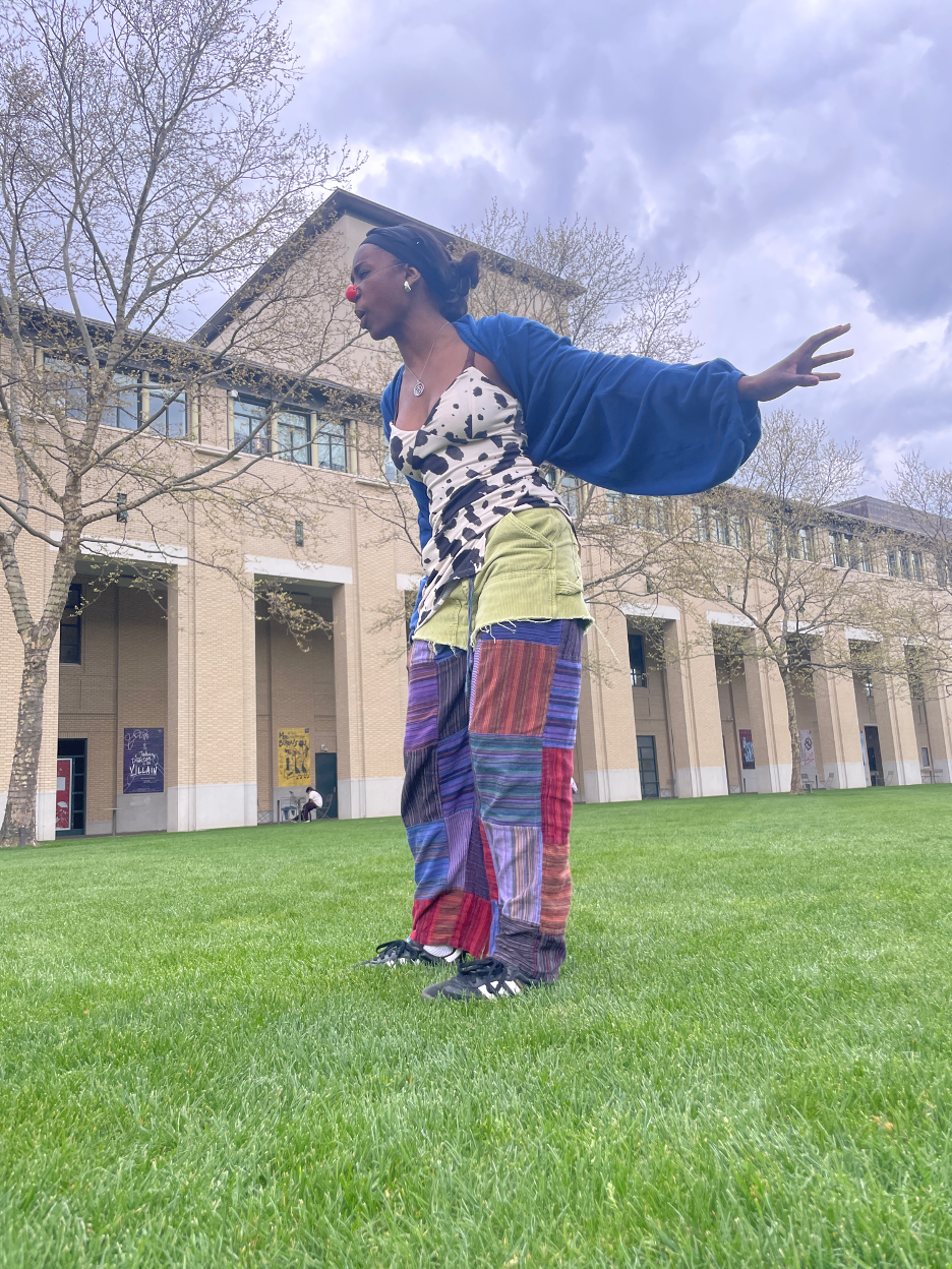 A person dancing outside on a lawn.