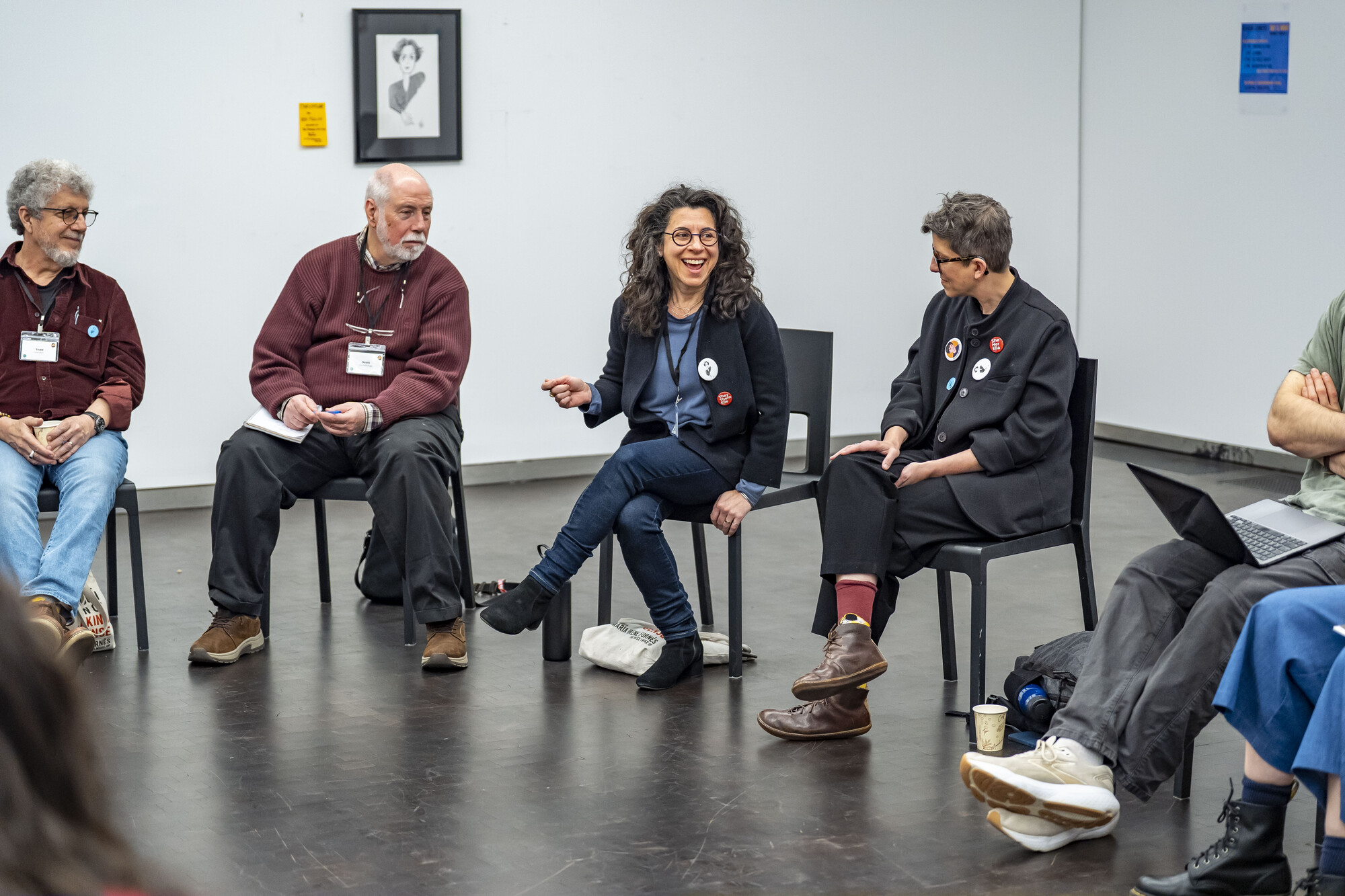 A group of people sitting in chairs conversing.