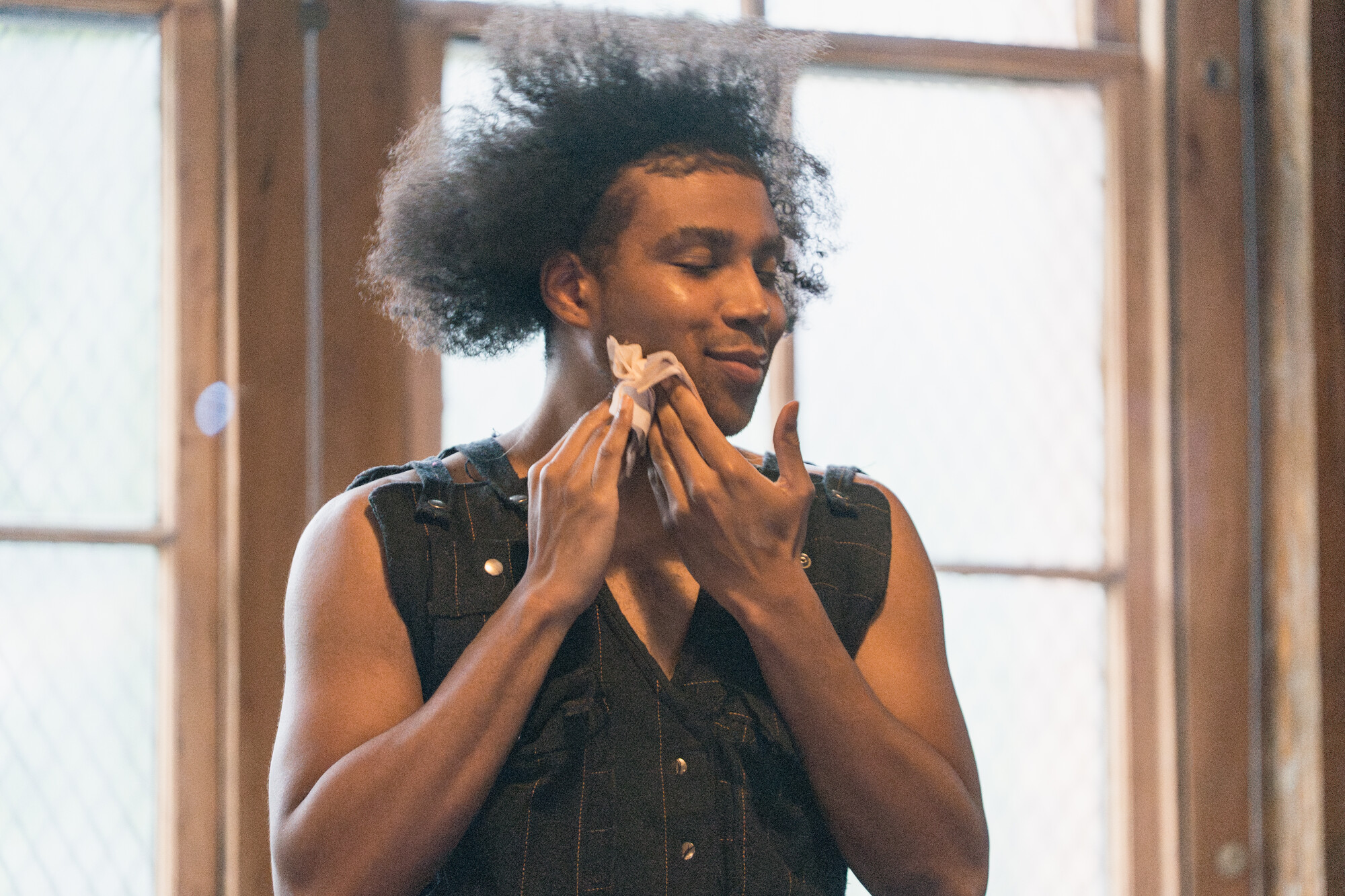 A person wiping their face clean with a cloth.