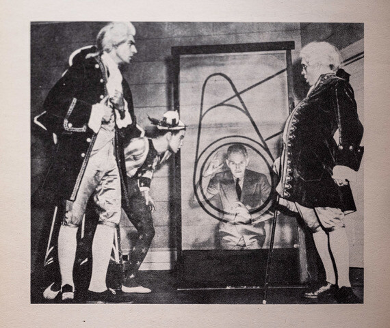 A black and white photo of people in colonial attire.