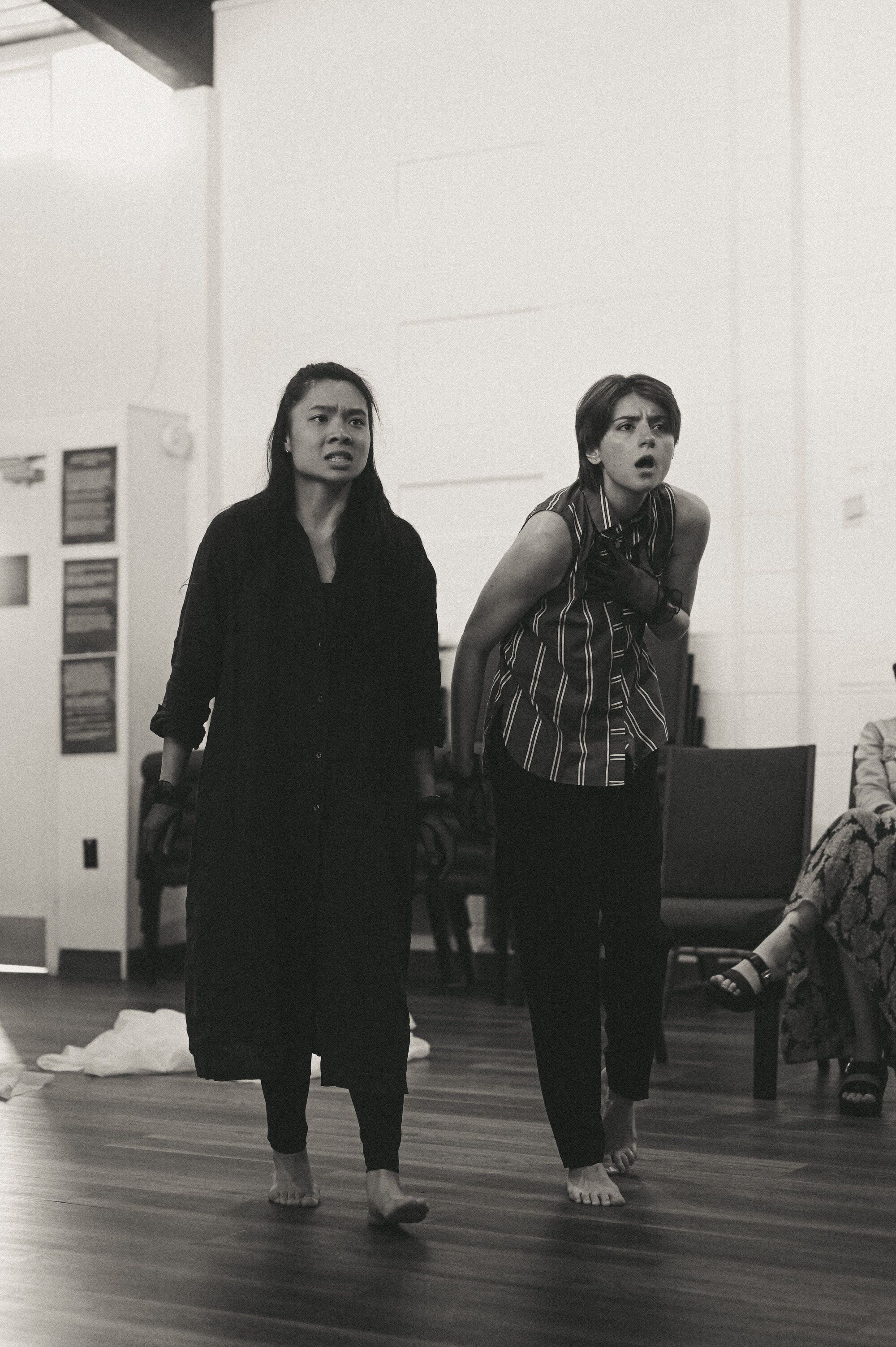 A black and white photo of two people standing and yelling at something off screen.