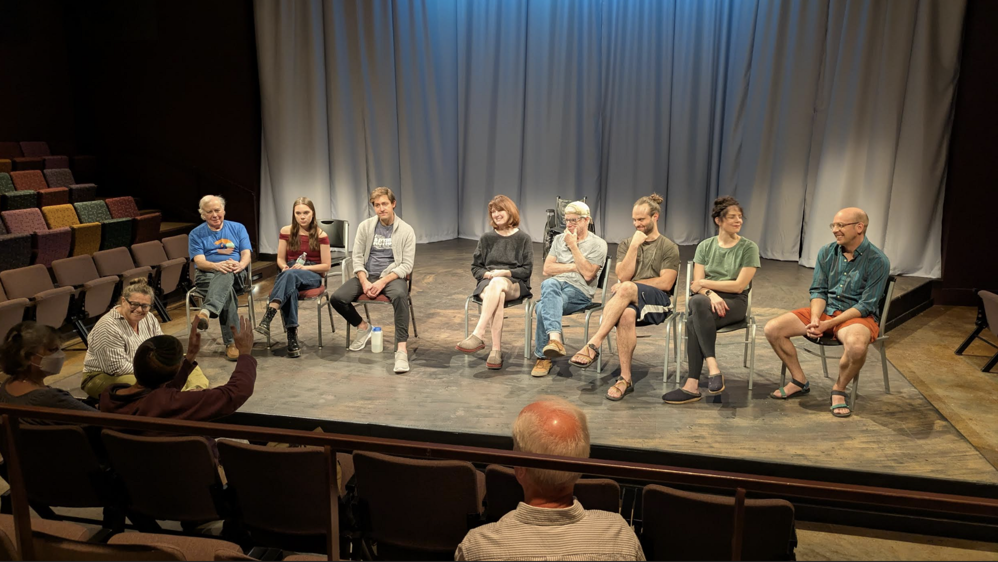A group of people sitting in chairs on a stage facing the audience.