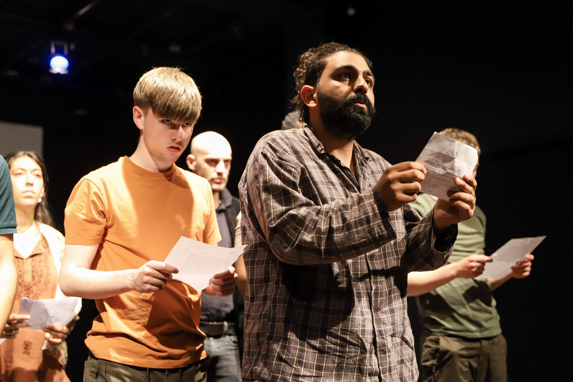 People on stage reading from small papers.