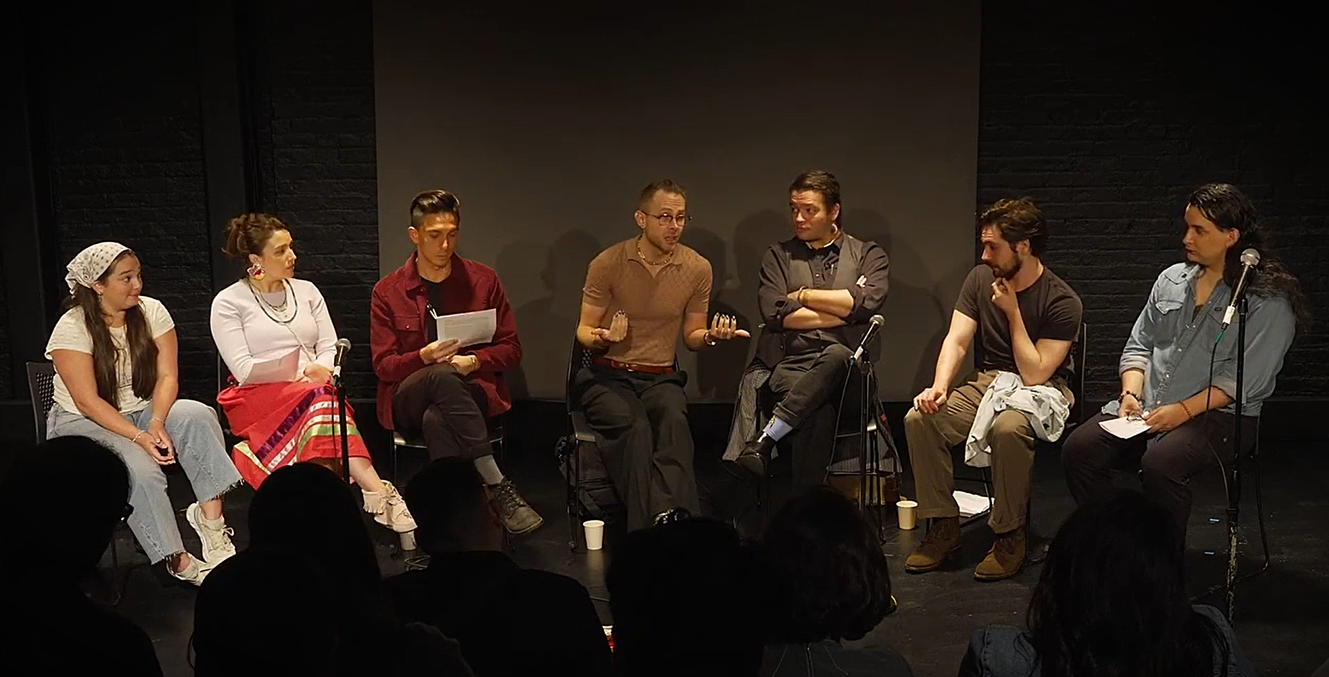 A group of people sitting in a row in chairs.