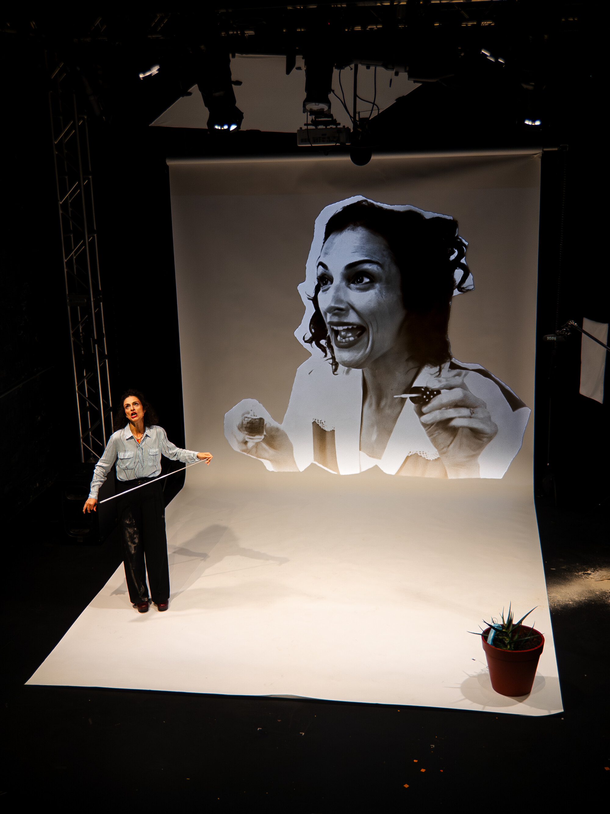 A woman on stage with a projection of her face behind her.