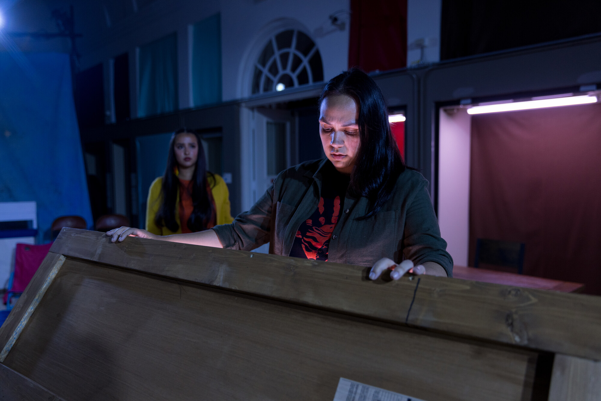 A person onstage opens a glowing chest.