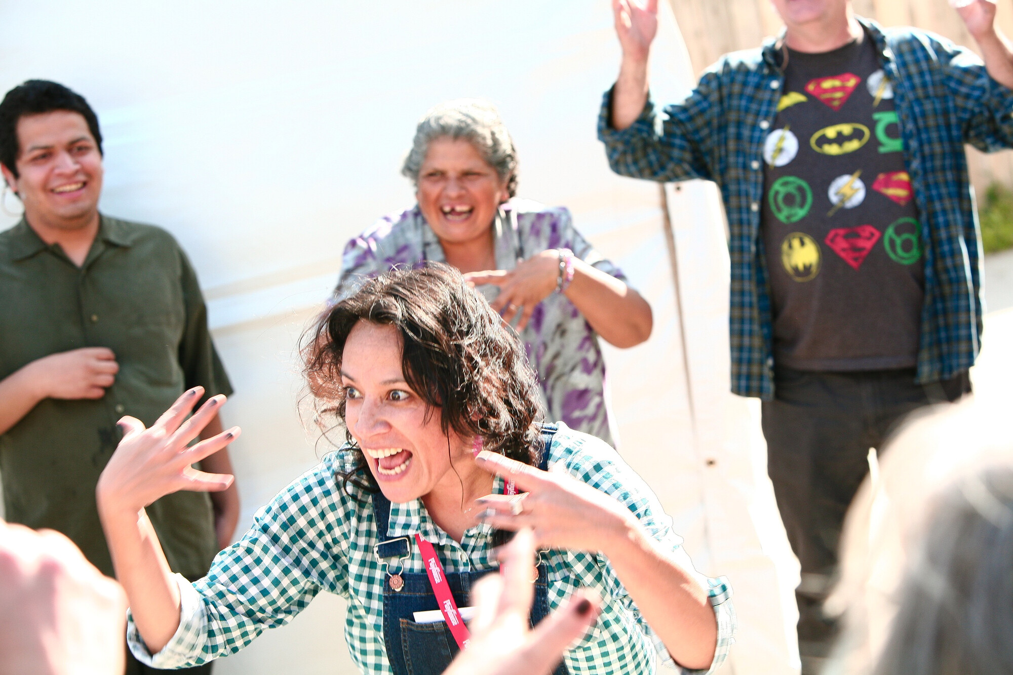 A circle of people laugh around a performer yelling.