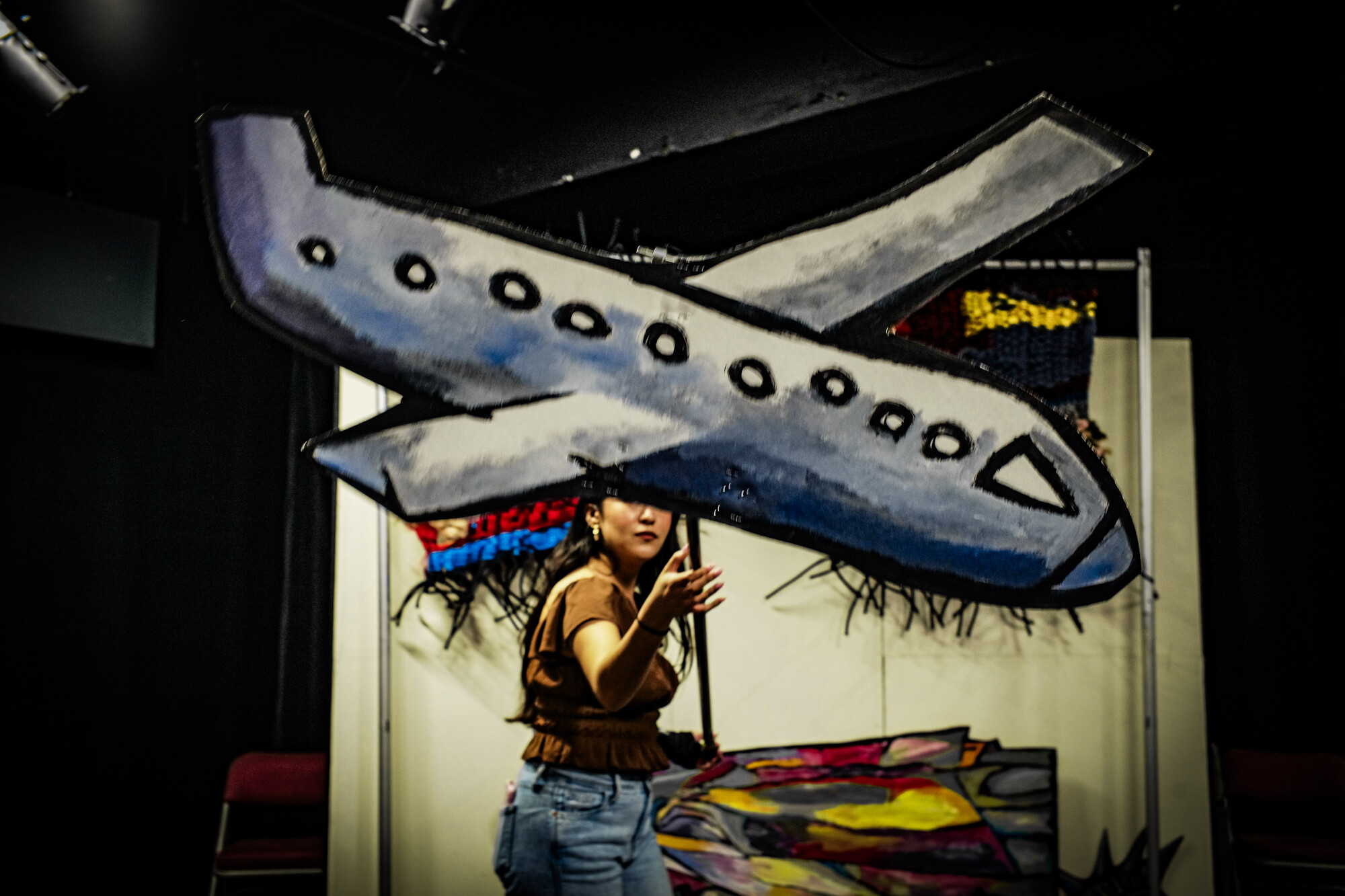 A person holding a plane puppet.