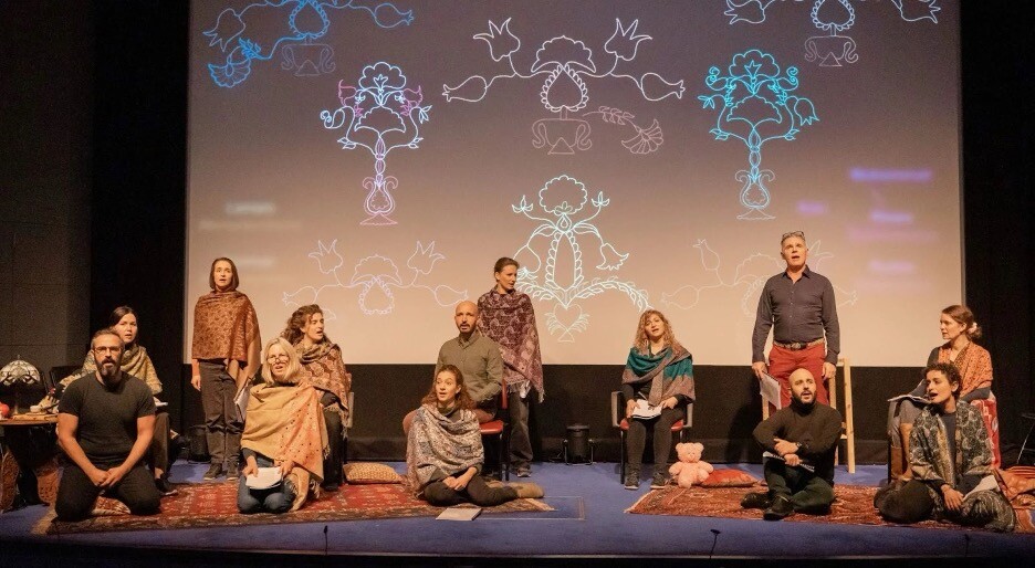 A group of people sit in front of a screen covered in drawings.