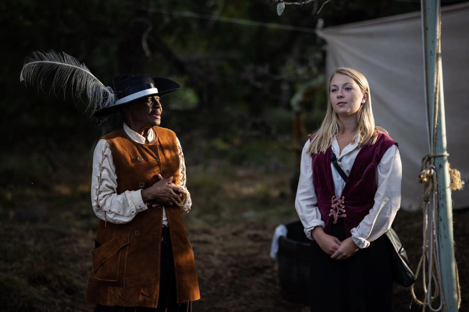 Two actors in Shakespearean garb stand onstage.