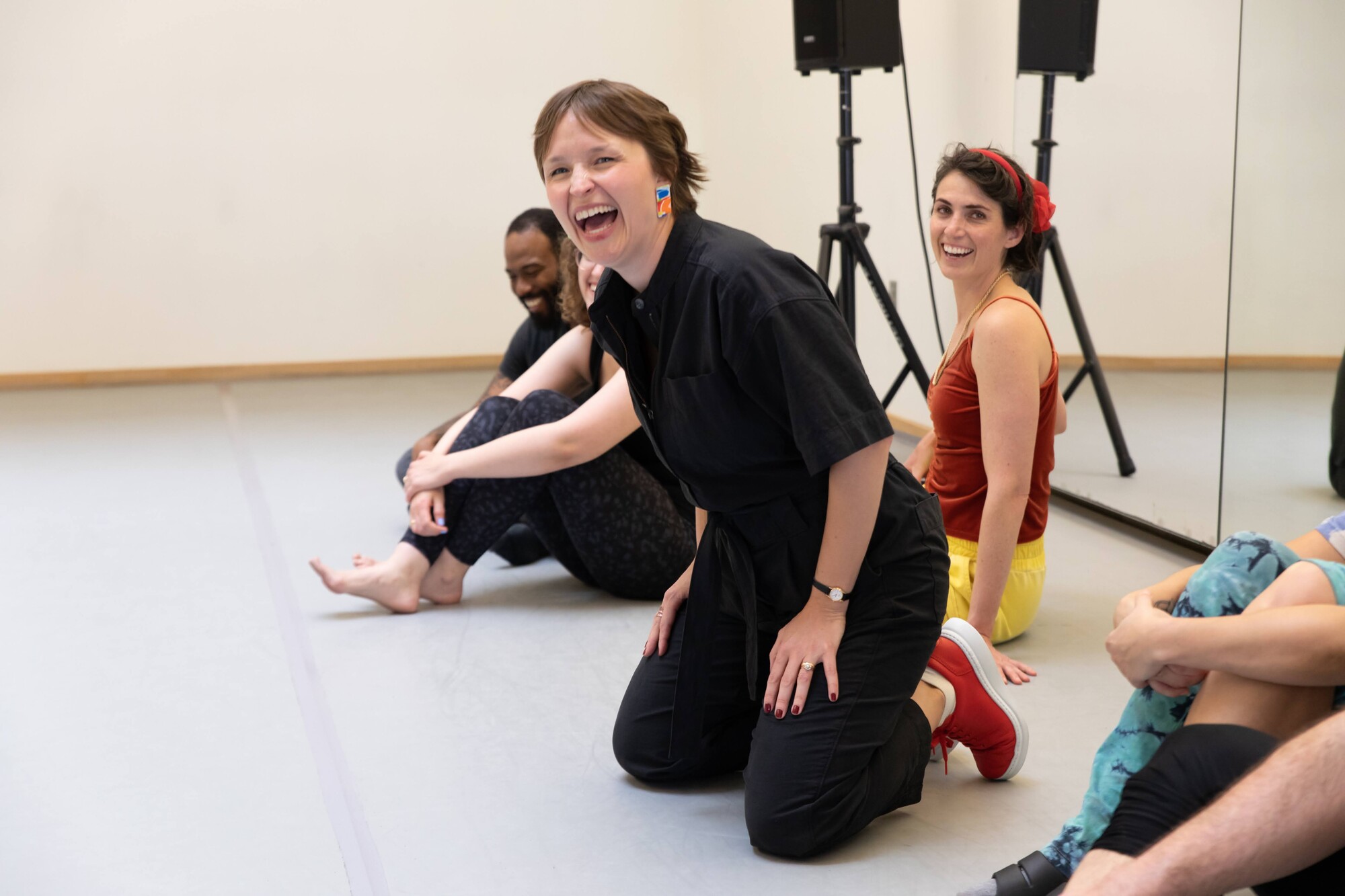 A person laughs while sitting on their knees.