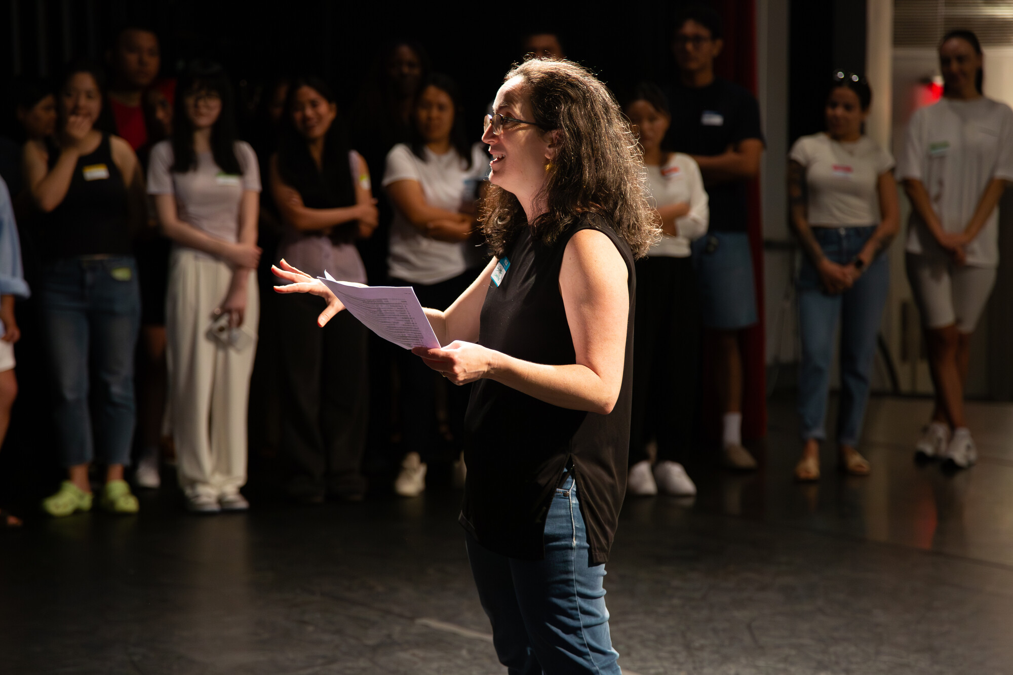 A person with long hair addresses a crowd.