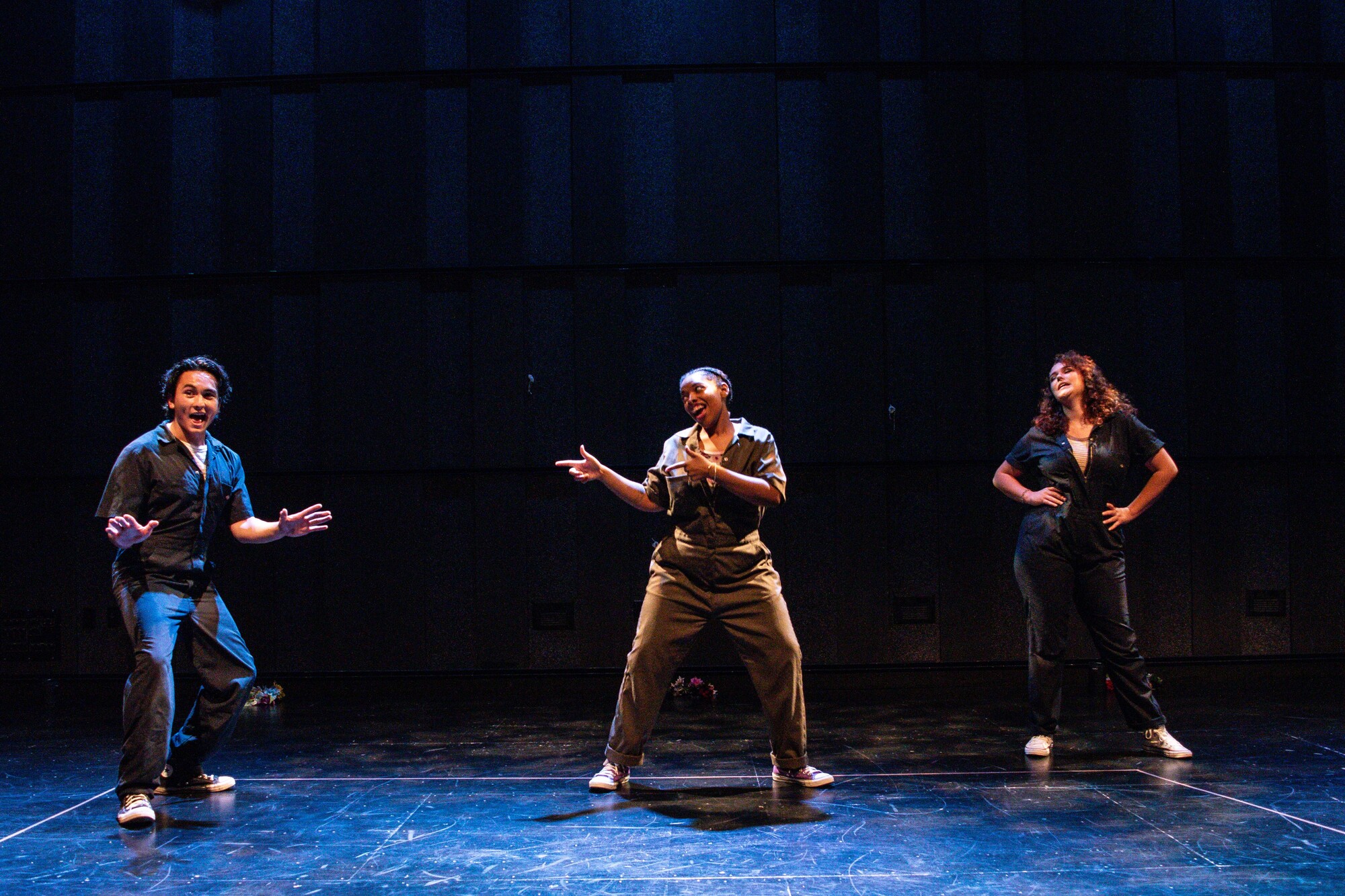 Three actors pose onstage.