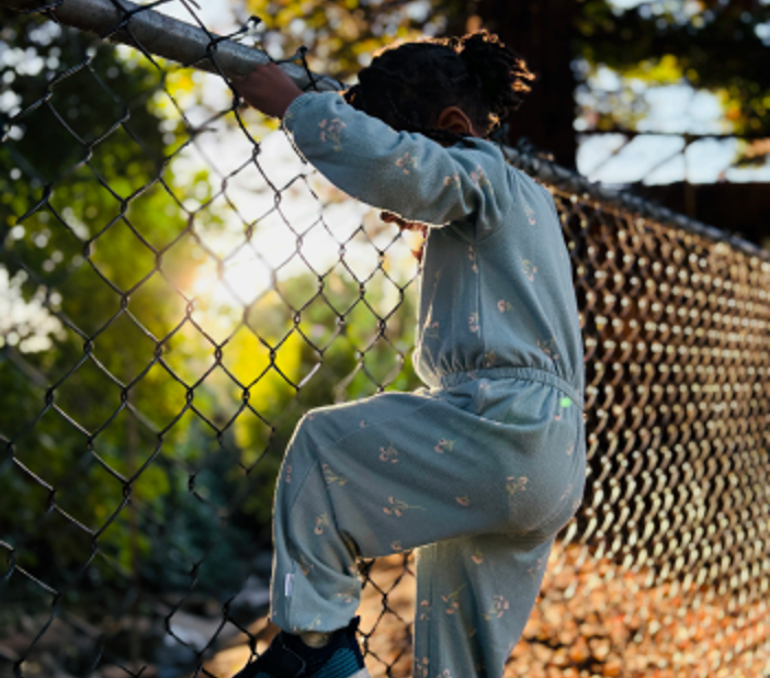 A child climbs a fence.