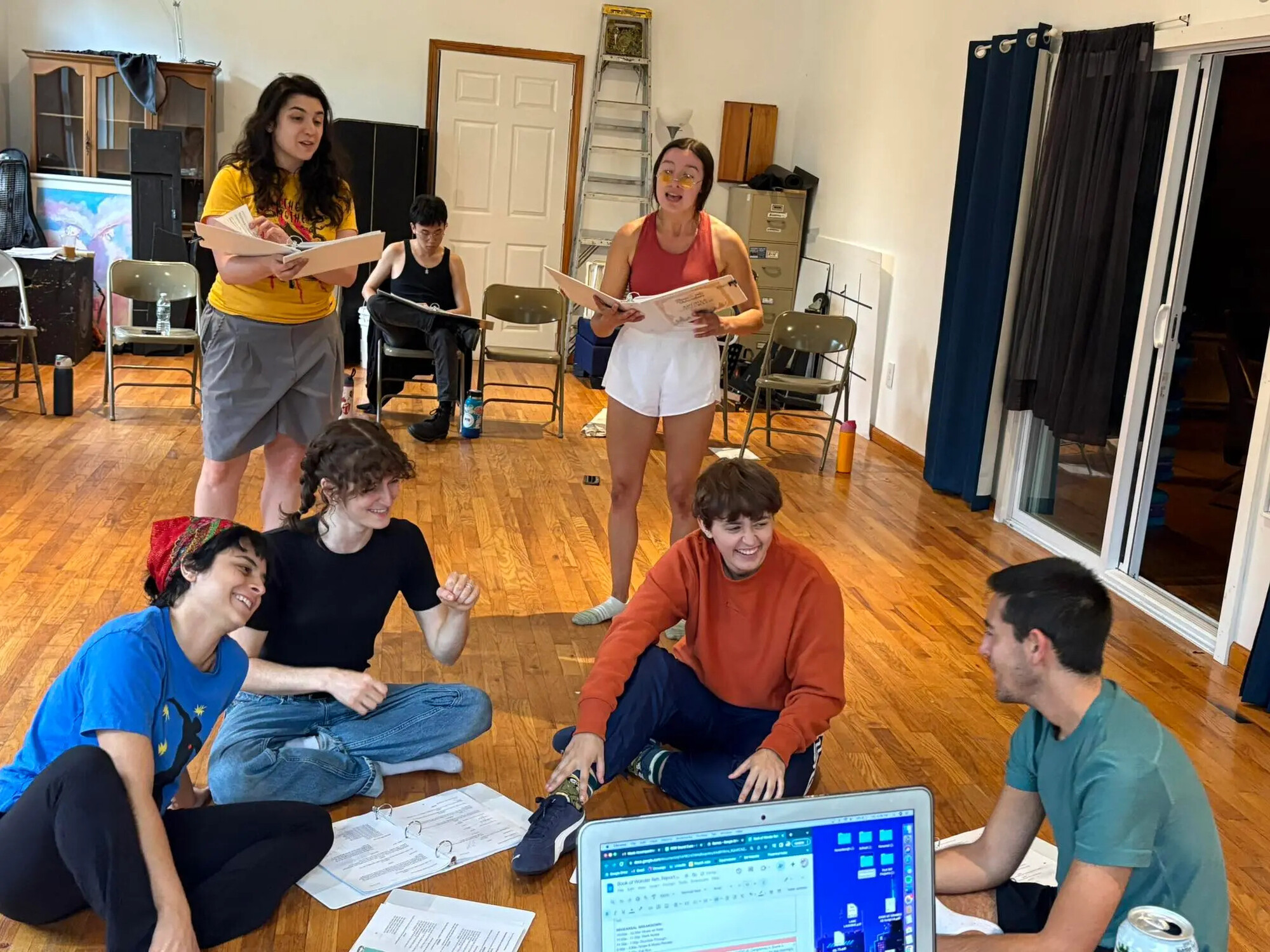 A group of students sit on the floor in a circle.