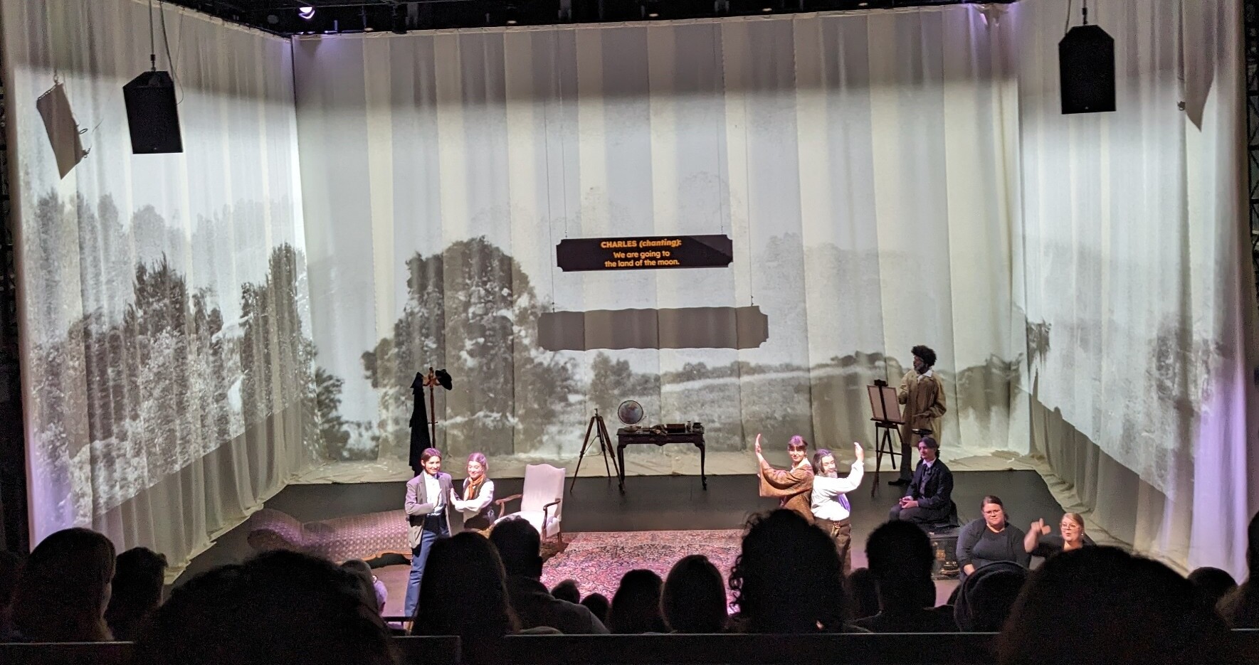 Actors perform onstage.