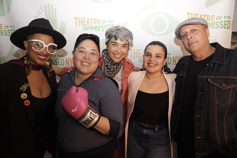A group of people pose with a boxing glove.