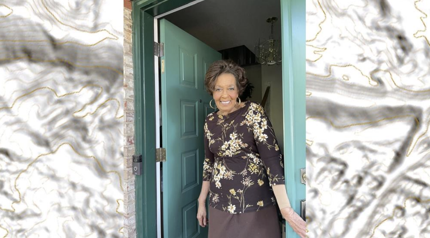 A woman stands in a doorway.