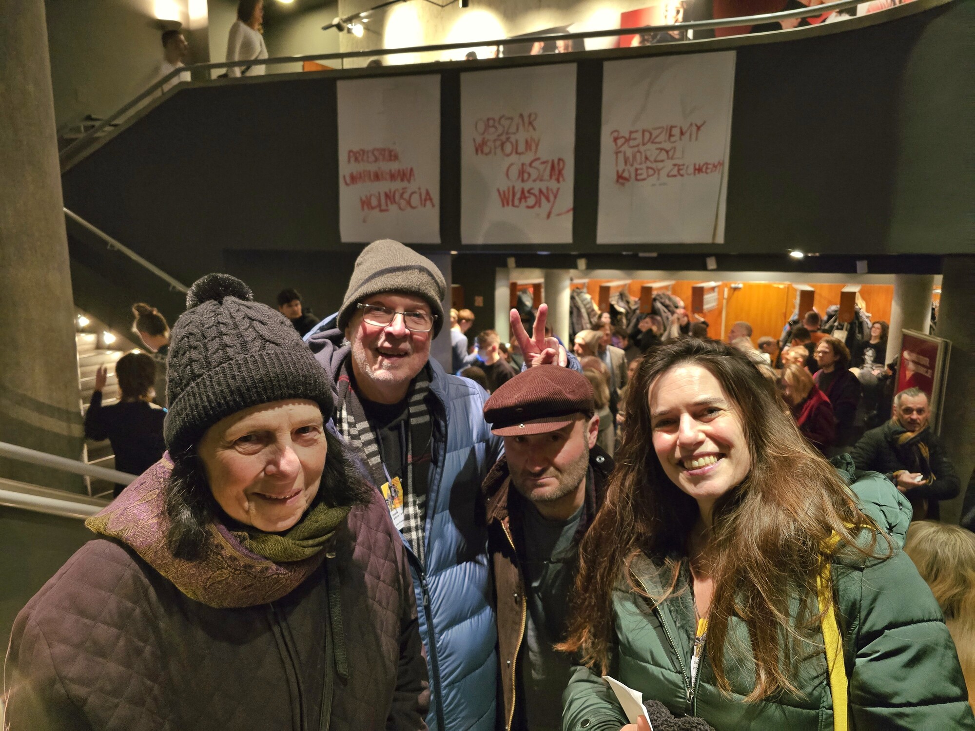 Four people stand in front of a series of banners.
