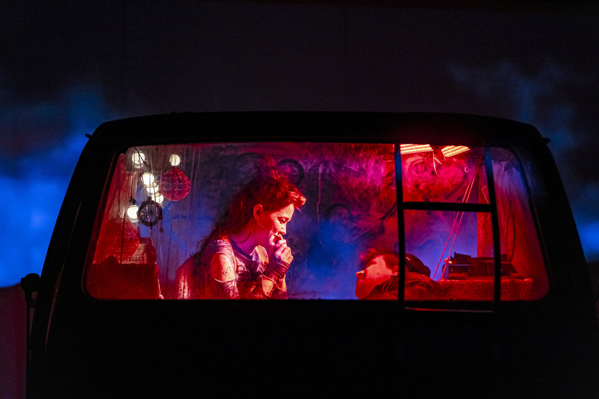 Two people embrace in the back seat of a car.