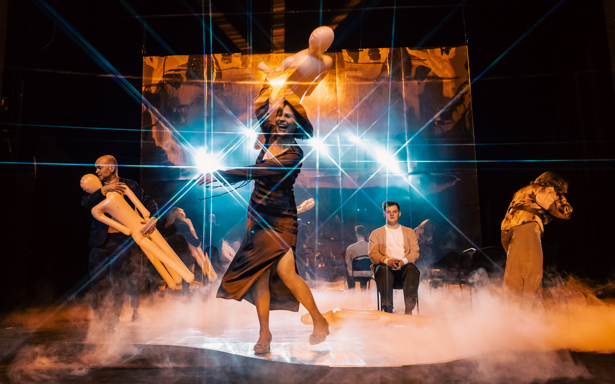 A person dances under bright lights onstage.