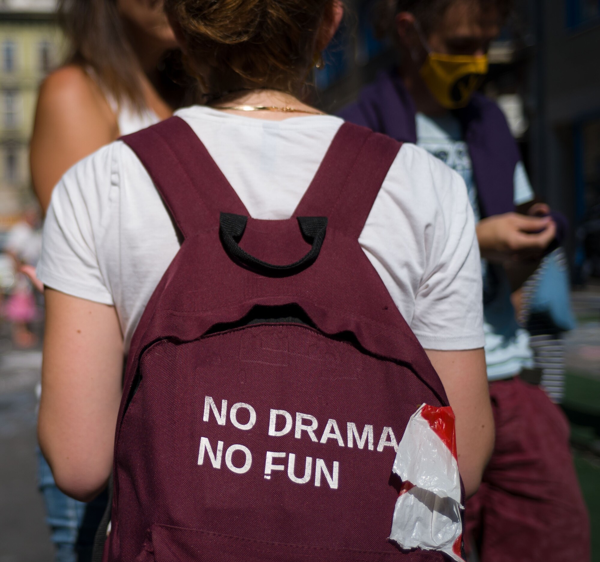 A person wearing a backpack that reads No Drama, No Fun.