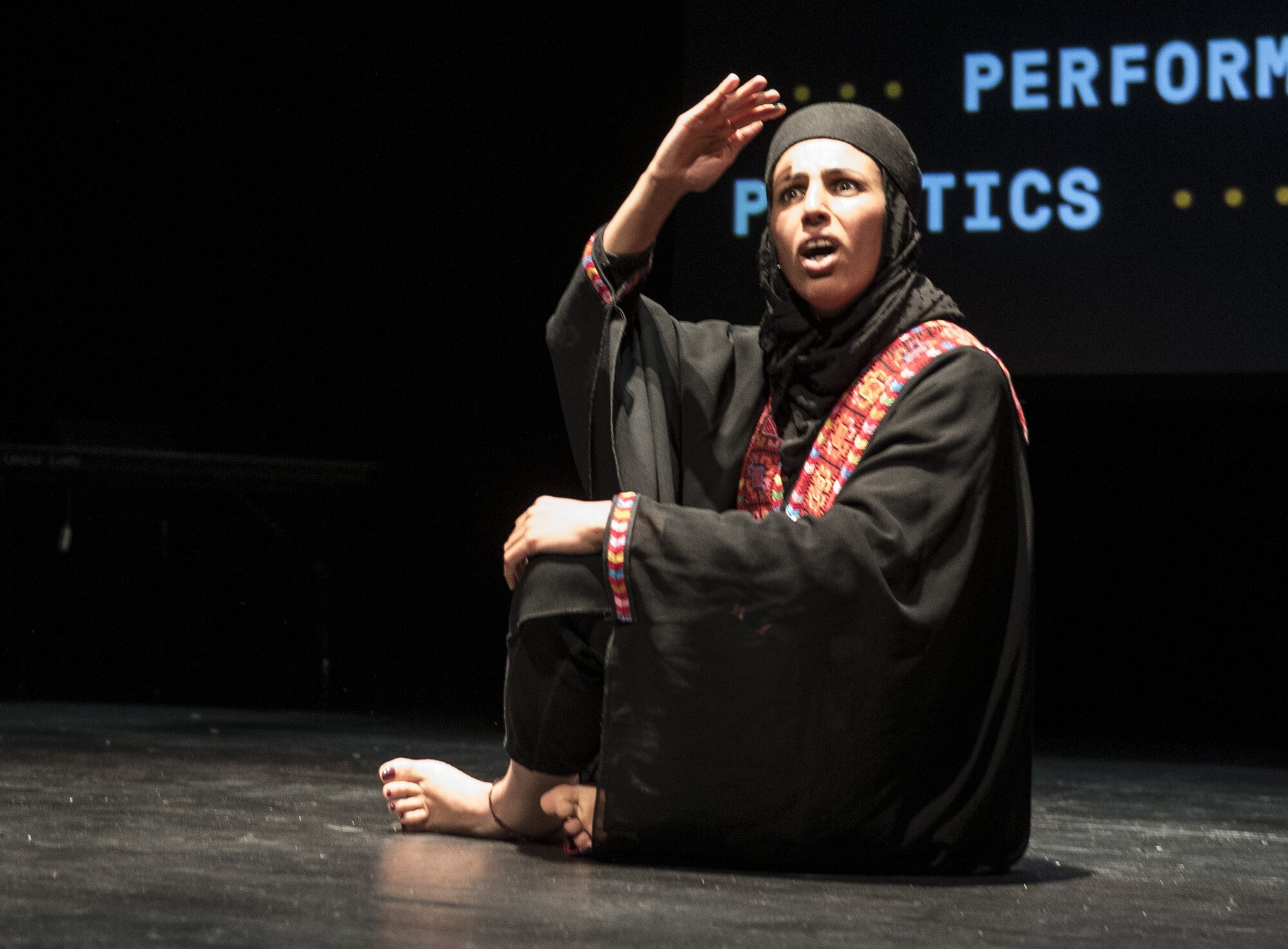A performer sits onstage.