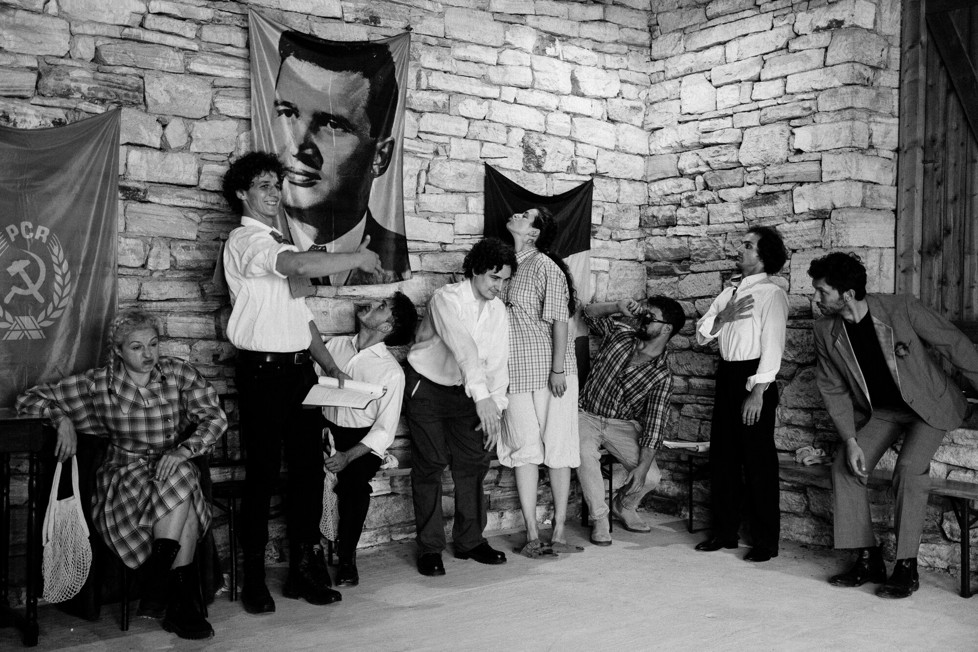 A group of people look up at a flag.