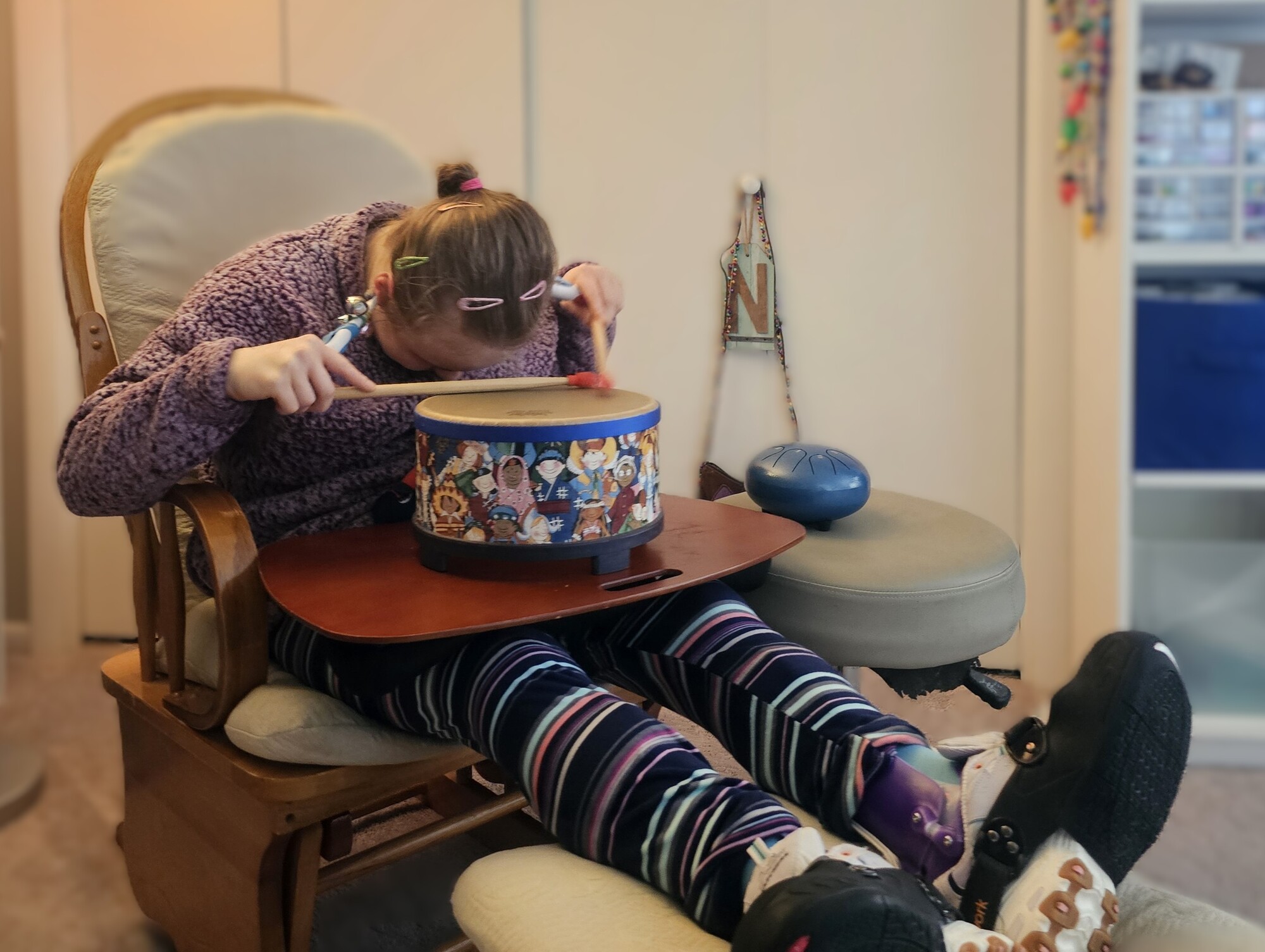 A person leans their head over a drum.
