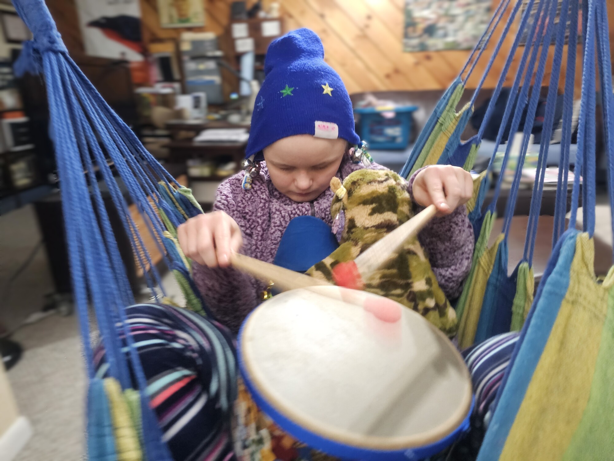 A person swings and holds a drum.