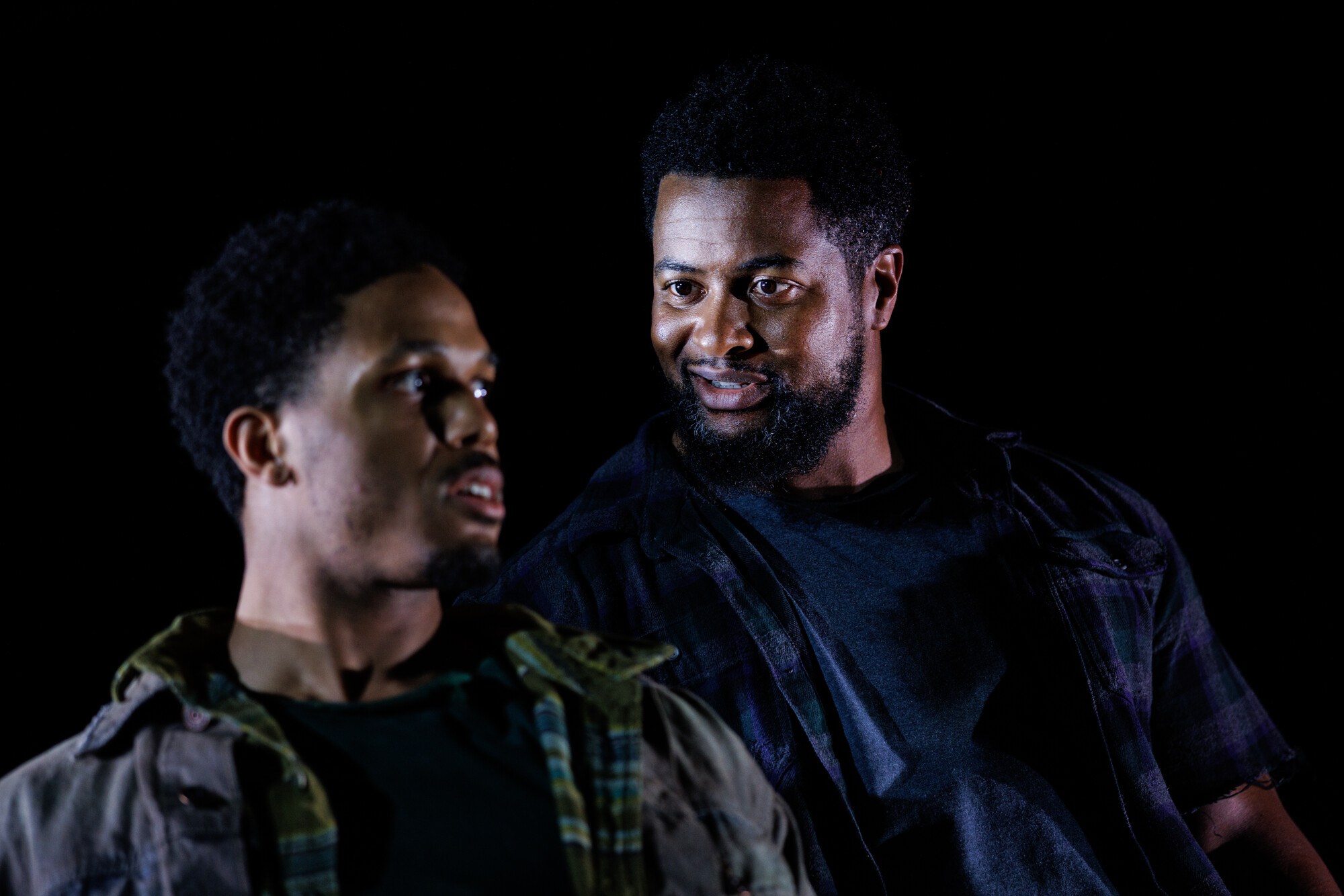 Two men look at each other onstage.