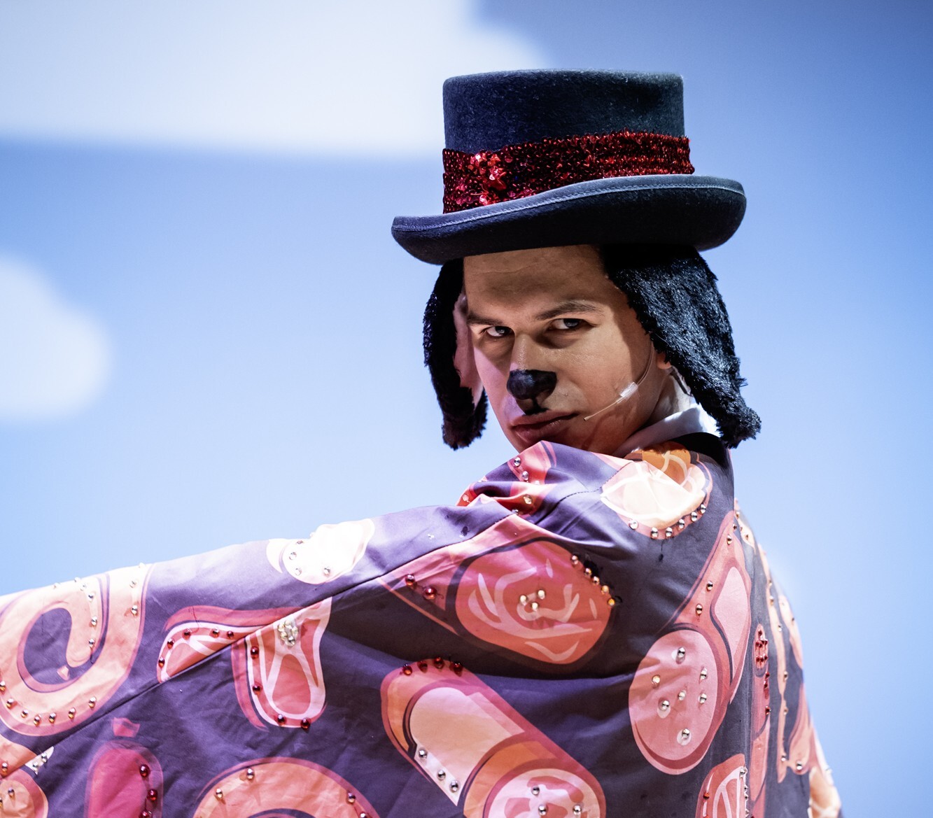 A person in a dog costume and a top hat poses for the camera.