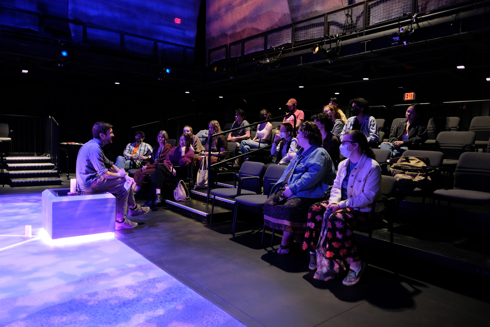 A director speaks to a group of students in a theatre.