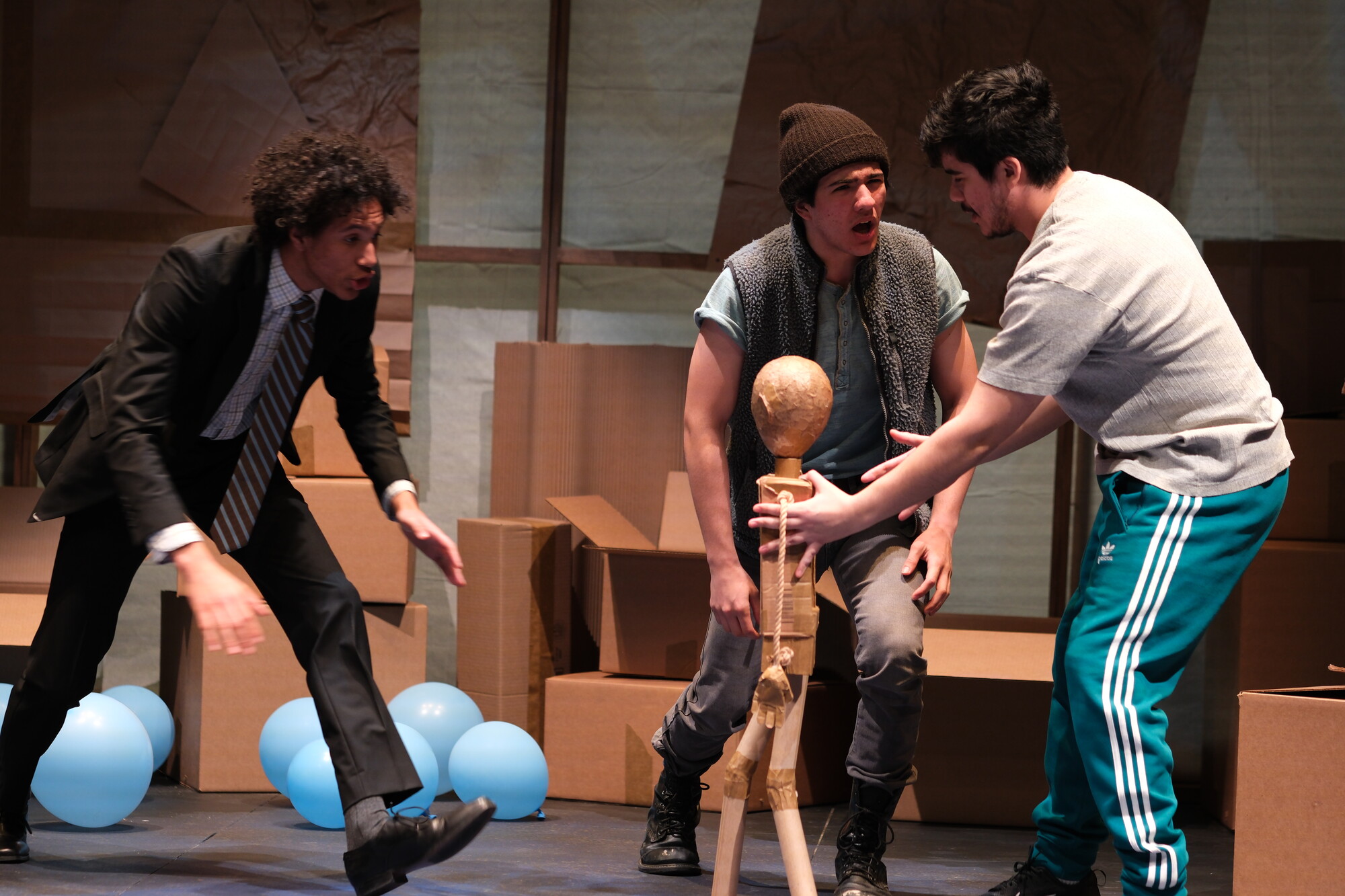 Three actors pilot a puppet onstage.