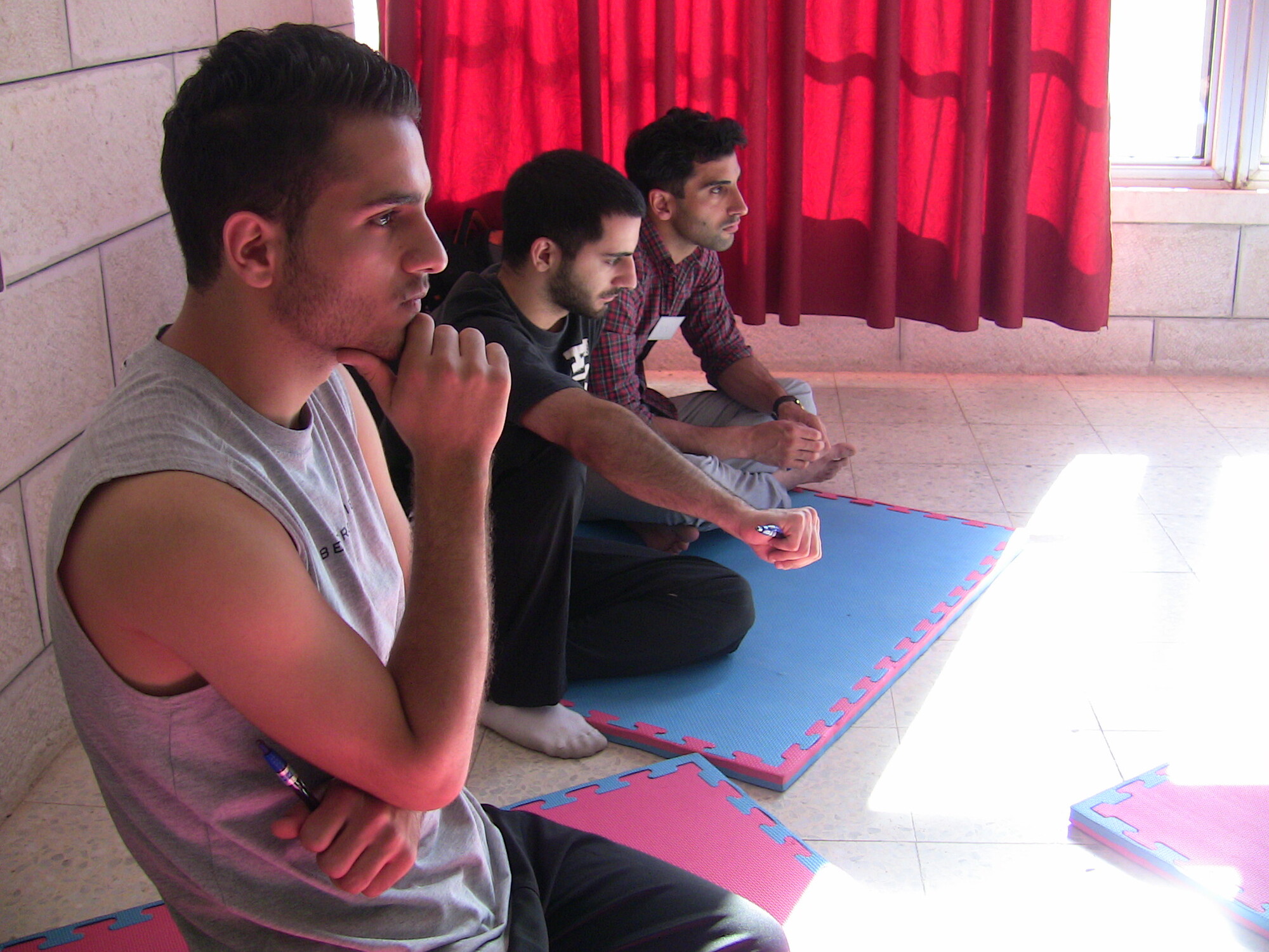 A man sitting on his knees thinking deeply.