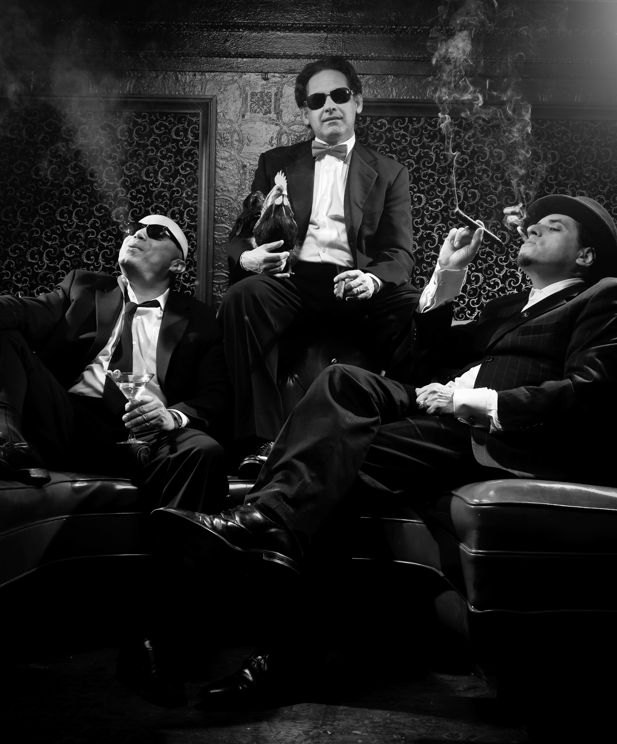 Three men in suits smoke in a saloon.