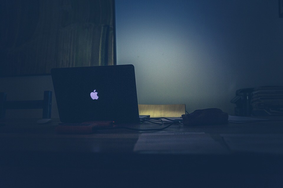 A laptop on a table at night.