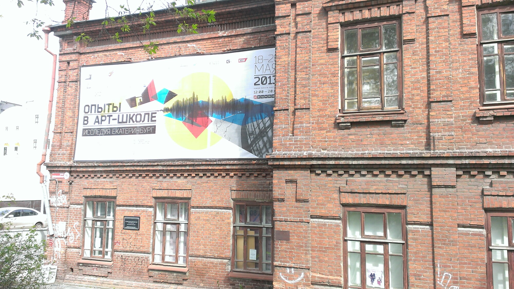 A billboard on the side of a brick building in Yekaterinburg.