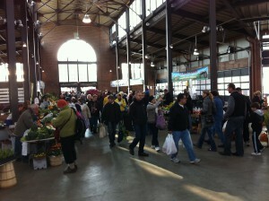 A crowd of people shopping at an indoor market.