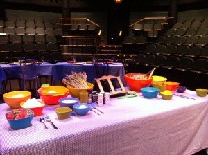 A table laden with colorful bowls onstage.