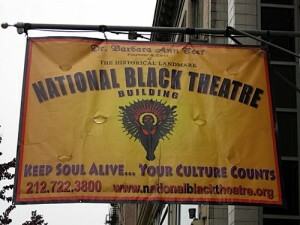 A banner promoting the National Black Theatre hangs from a flagpole.